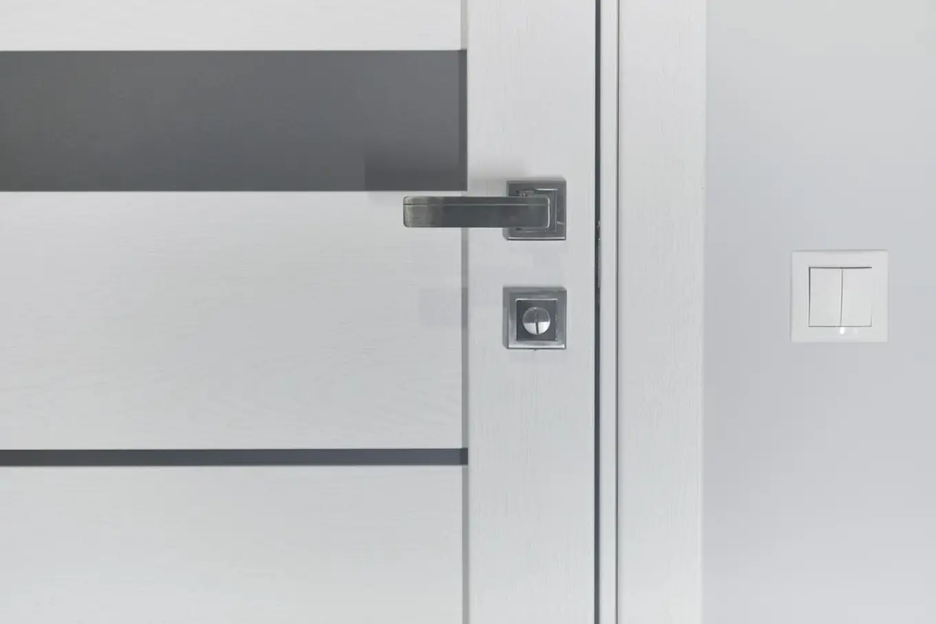 białe drzwi ze srebrną klamką